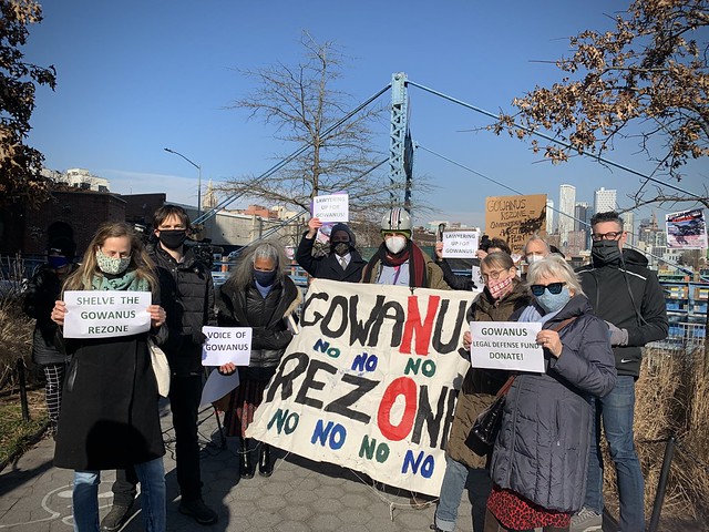 Masked residents stand with a large handmade sign reading Gowanus No Rezone.