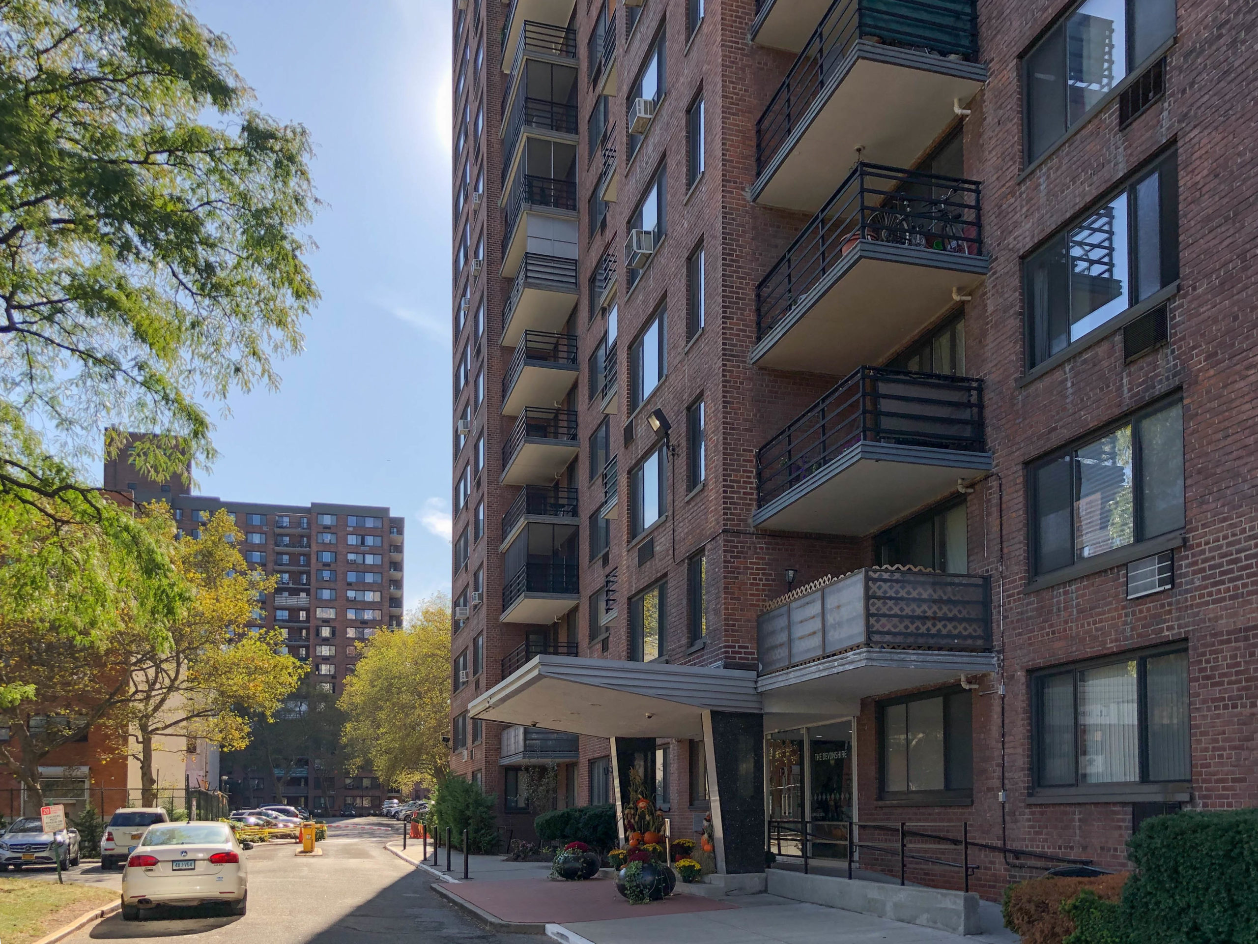 Crowded community meeting or exterior Lenox Terrace footage in news video.